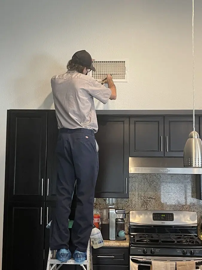Technician inspecting an air vent during HVAC service in Nether Providence